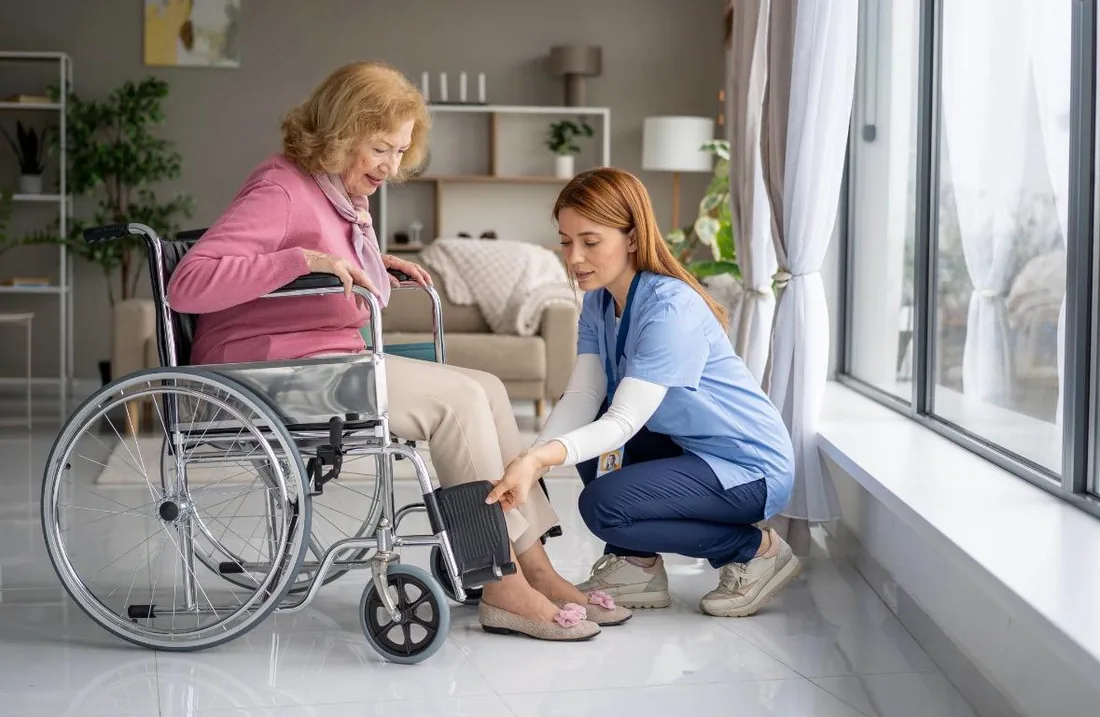 Caregiver assisting an older adult with daily mobility needs